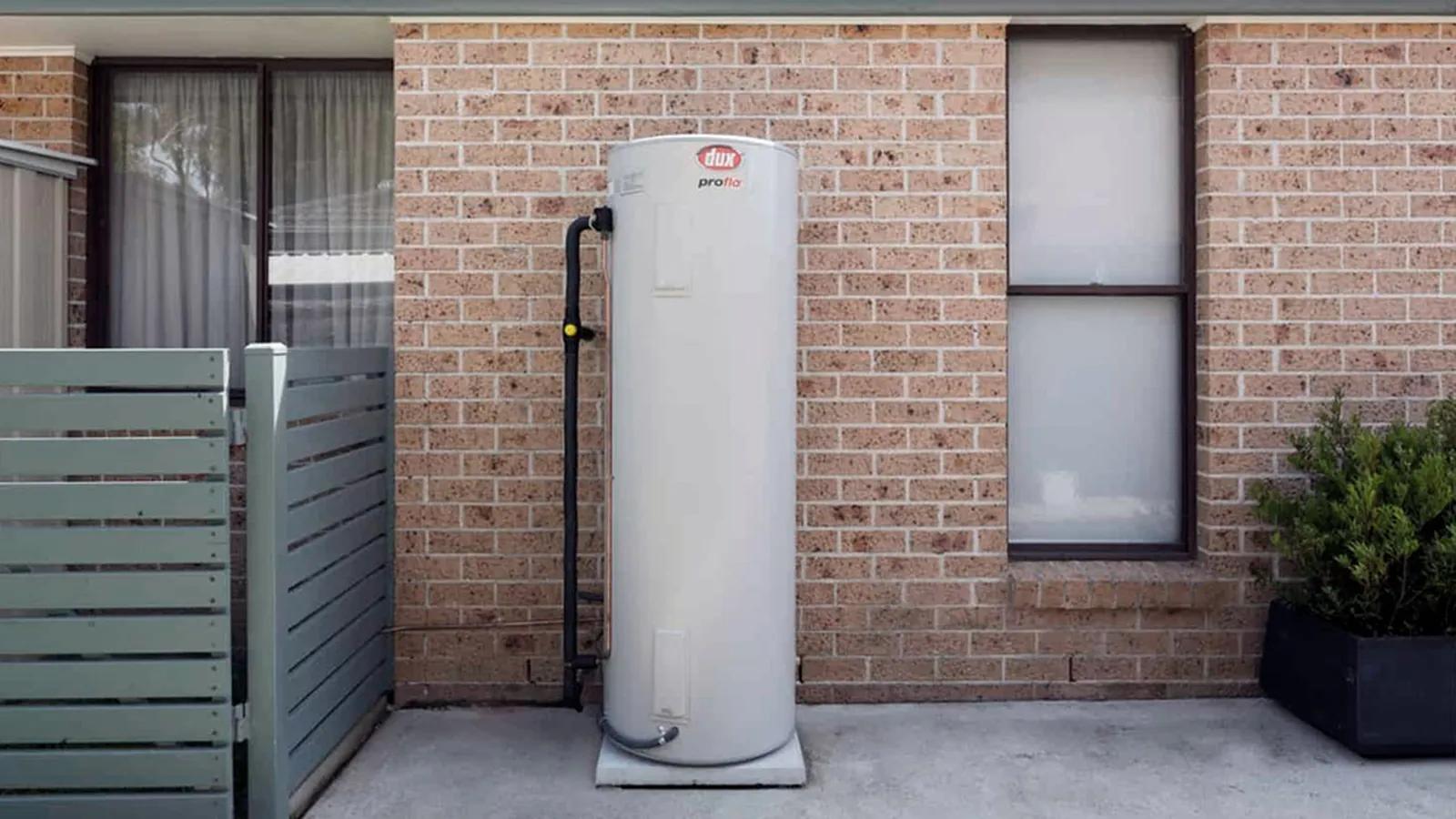 Dux electric storage hot water system installed against a brick wall
