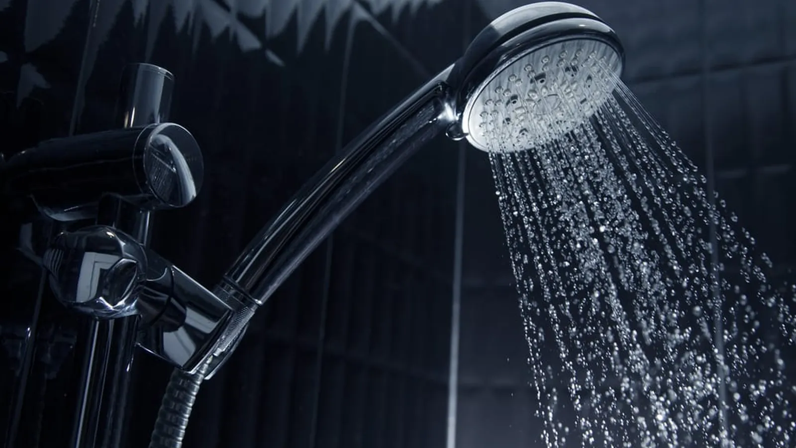 Close-up of a shower head running hot water